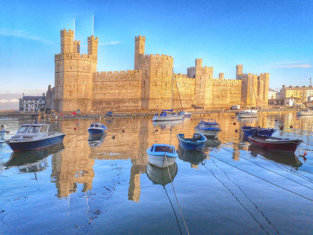 Caernarfon Castle surrounded by boats