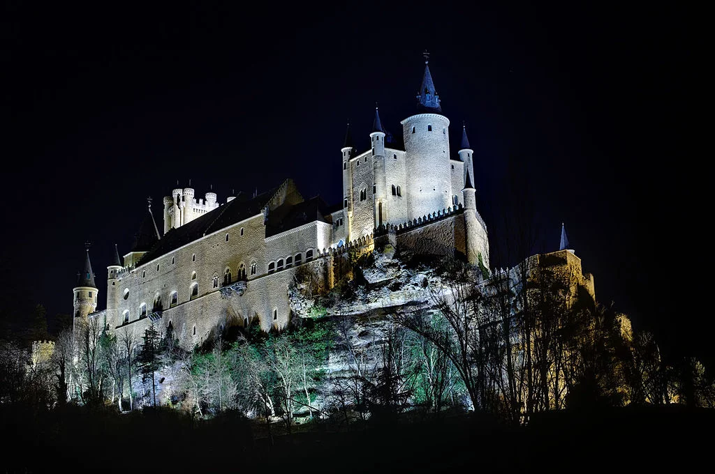 Alcazar of Segovia at the night time shot from below. The castle and the granite hill it stands on are beautifully enlightened.