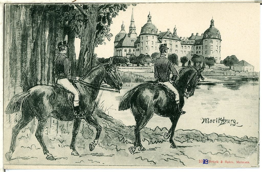 A postcard from 1899 with two horsemen and the Moritzburg castle in the background in black and white.