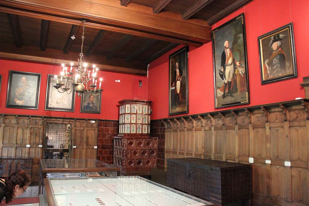 The inside view of one of the museum in Altena Museum with red walls and paintings.