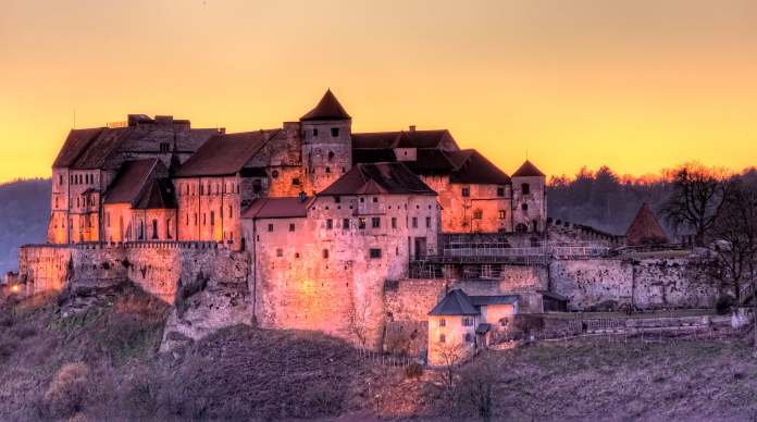 A beautiful view of Burghausen Castle in twilight evening with lights turned on..