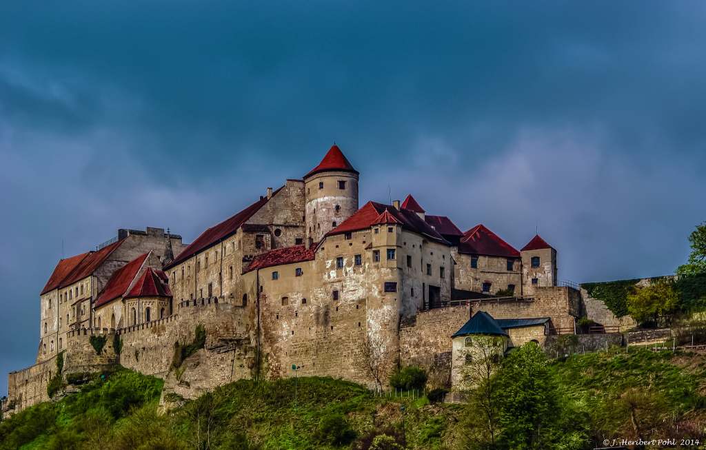 Worm's eye view of the gothic architecture of this castle and the hilly geography of the ridge on which it is located.