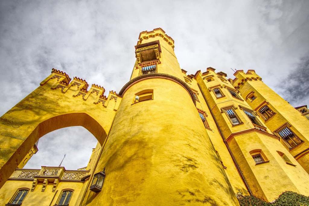 Steep high bright yellow wall of the Hohenschwangau castle from the bottom.