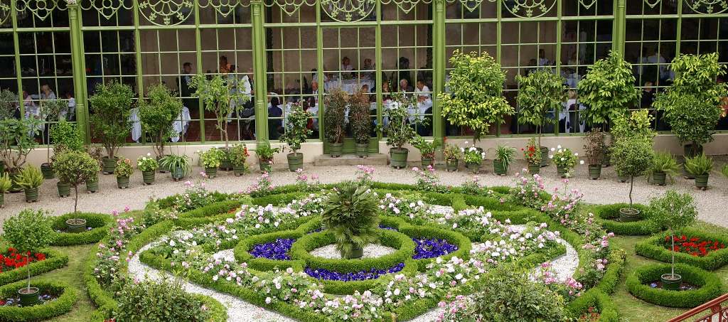 Beautiful pavilion garden of the Schwerin castle with red, purple and white flowers in front of the dining area.