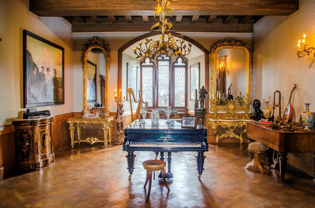 Rheinstein Castle's golden interior with piano display, beautiful chandelier and musical instruments.