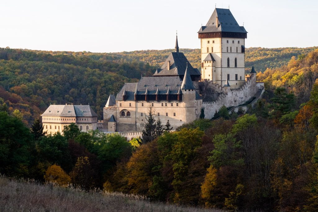 Karlštejn Castle's view at the mountain. surrounded by trees.