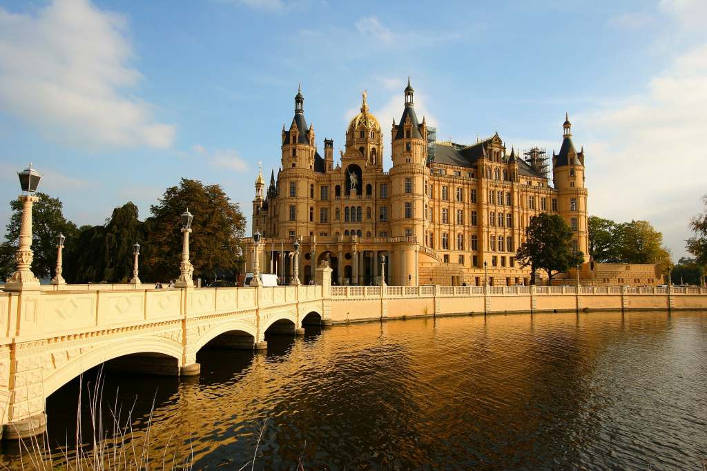 Schwerin Castle perspective before crossing the bridge surrounded by water and sunshine