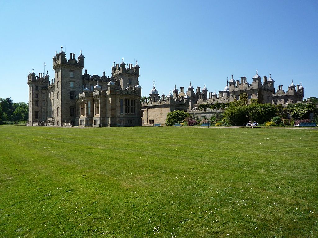 A dramatic view of the castle from across its green grounds . 