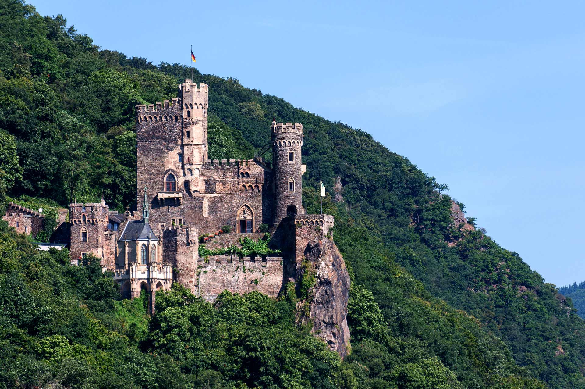 Beautiful view of Rheinstein Castle from afar surrounded by green trees