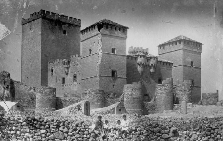 Castillo Ampudia circa late 19th century to early 20th with four people sitting on rocks.