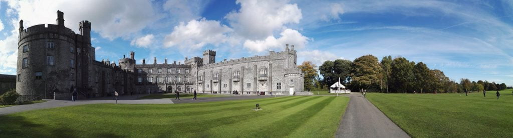 A wide-frame shot of Kilkenny’s present facade with green surroundings.