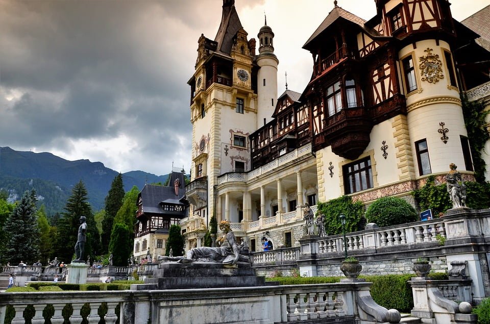 A picturesque autumnal view of Peles Castle and surroundings.