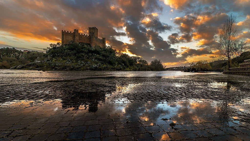A stunning image of the Castle of Almoural and its surroundings against an evening sky.