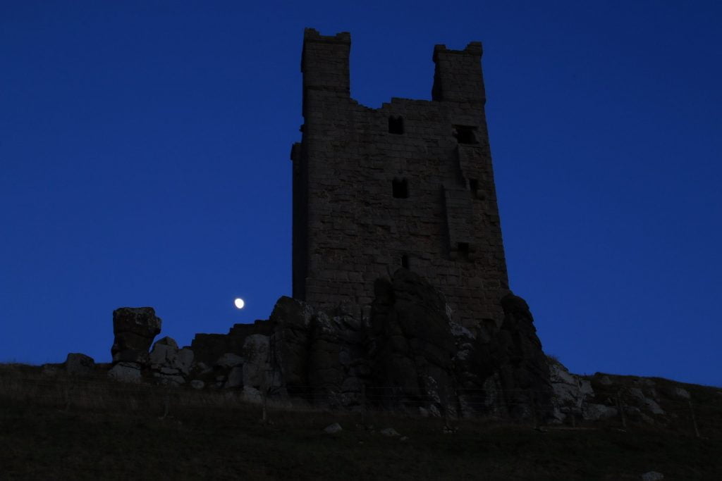 Dunstanburgh Castle at night.