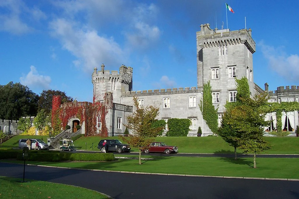 The beautiful Dromoland Castle with cars and trees at the front. 