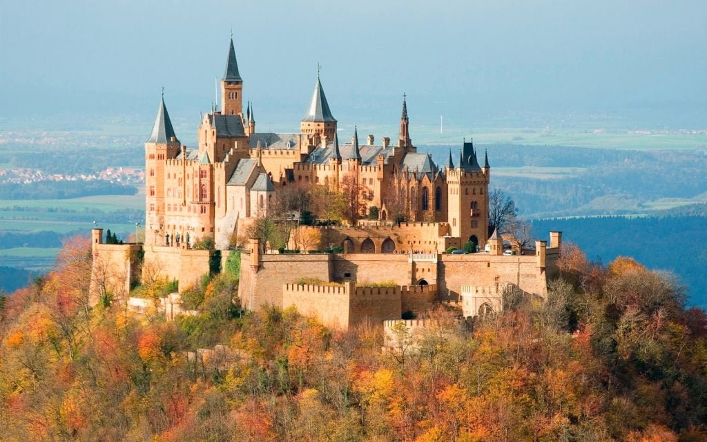 The picturesque view of Hohenzollern Castle surrounded by trees.