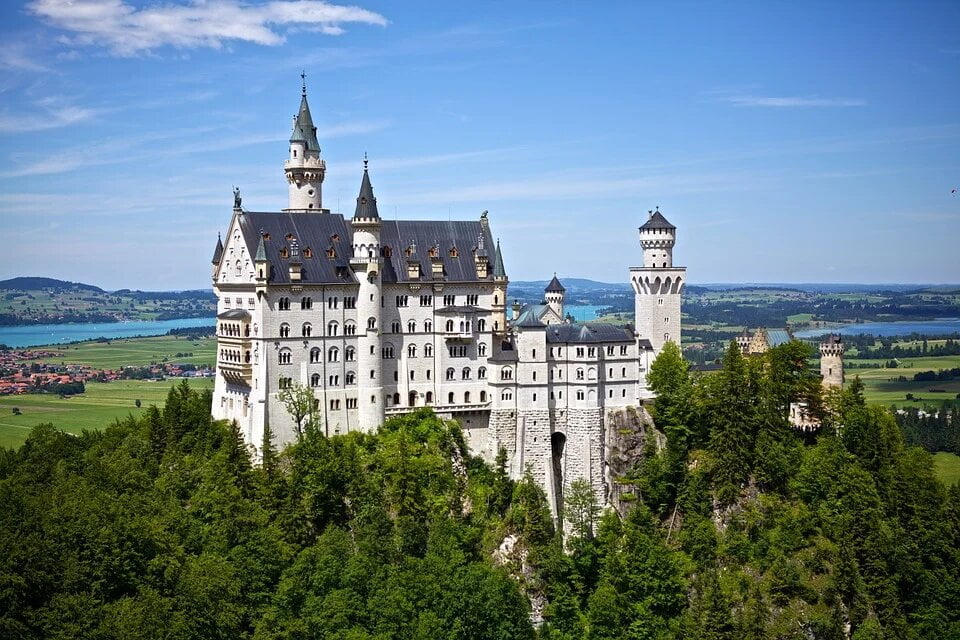 The magnificent view of Neuschwanstein Castle surrounded by trees.