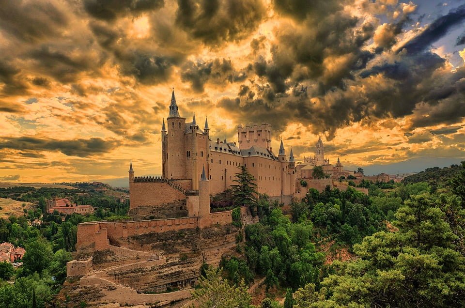 The stunning view of Alcazar de Segovia Castle surrounded by trees.
