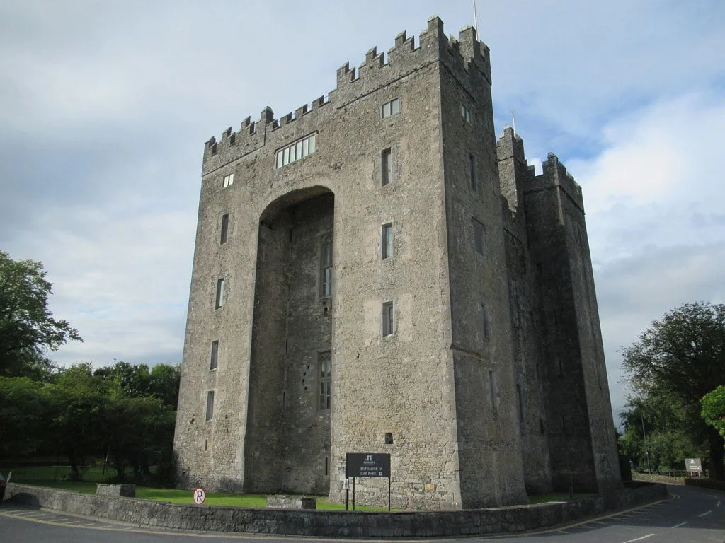 top 10 castles to visit in ireland The tower of Bunratty Castle in the middle of the road.