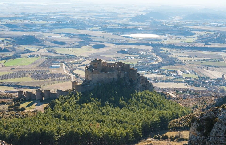 Castle of Loarre's panoramic aerial view where you can see the village and trees.