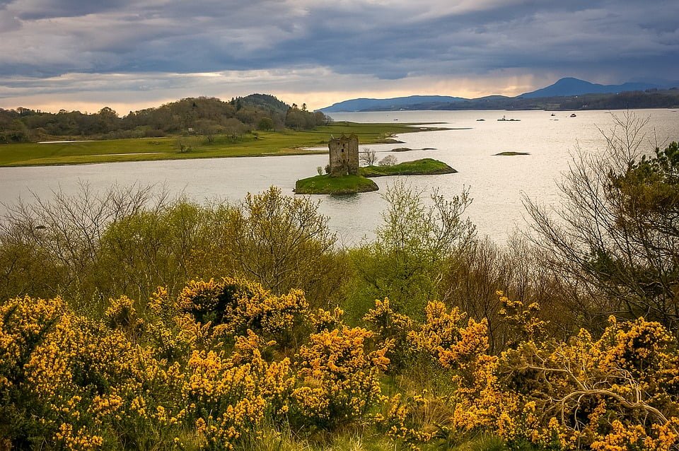 Castle Stalker in the middle of a small island surorunded by water.
