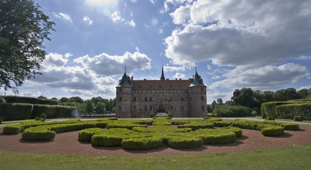 The view of Egeskov Castle in front of the maze garden.