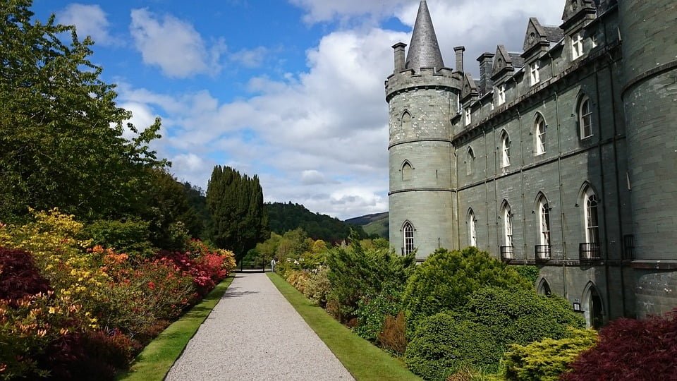 The garden at Inveraray Castle surrounded with green trees, bushes and flowers.