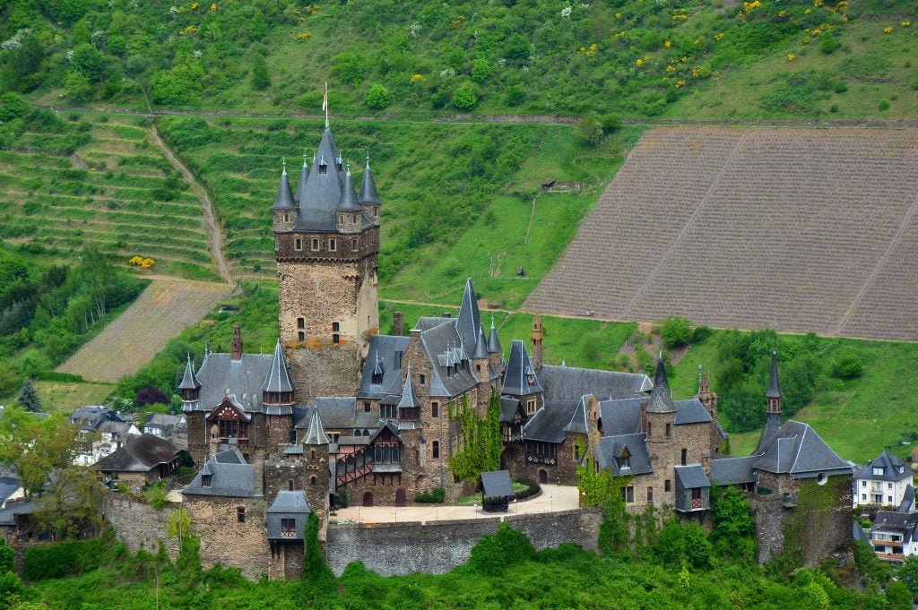 The view of Reichsburg Castle from above surrounded by greens.