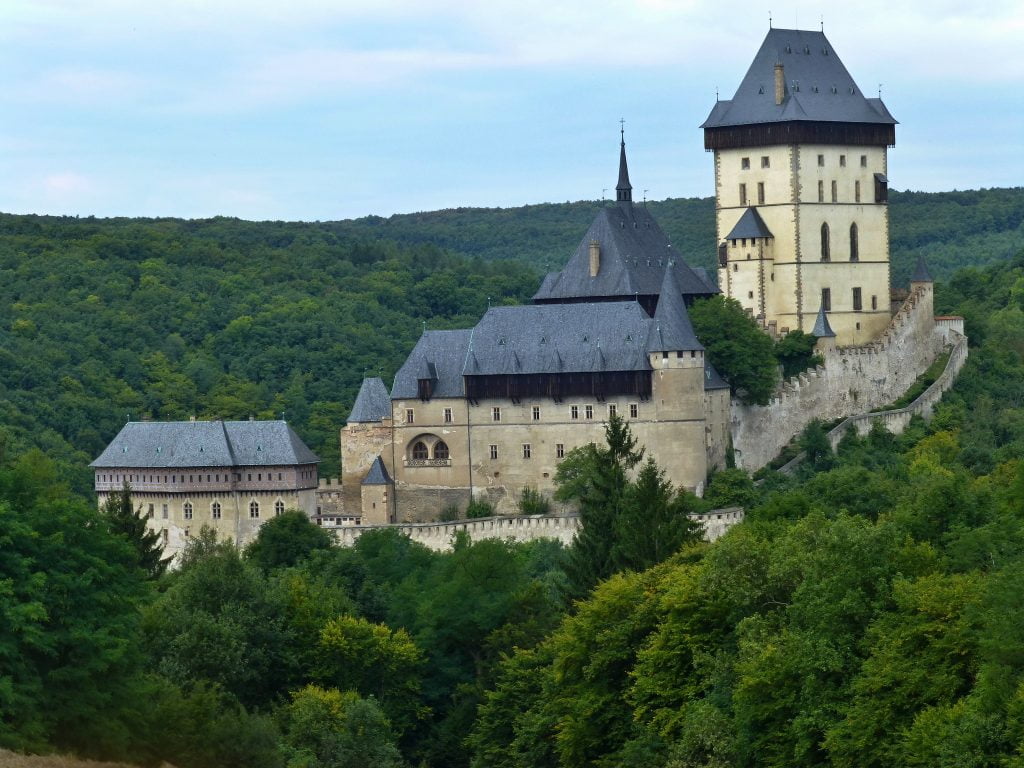 Karlstejn Castle rising above the surrounding forest.