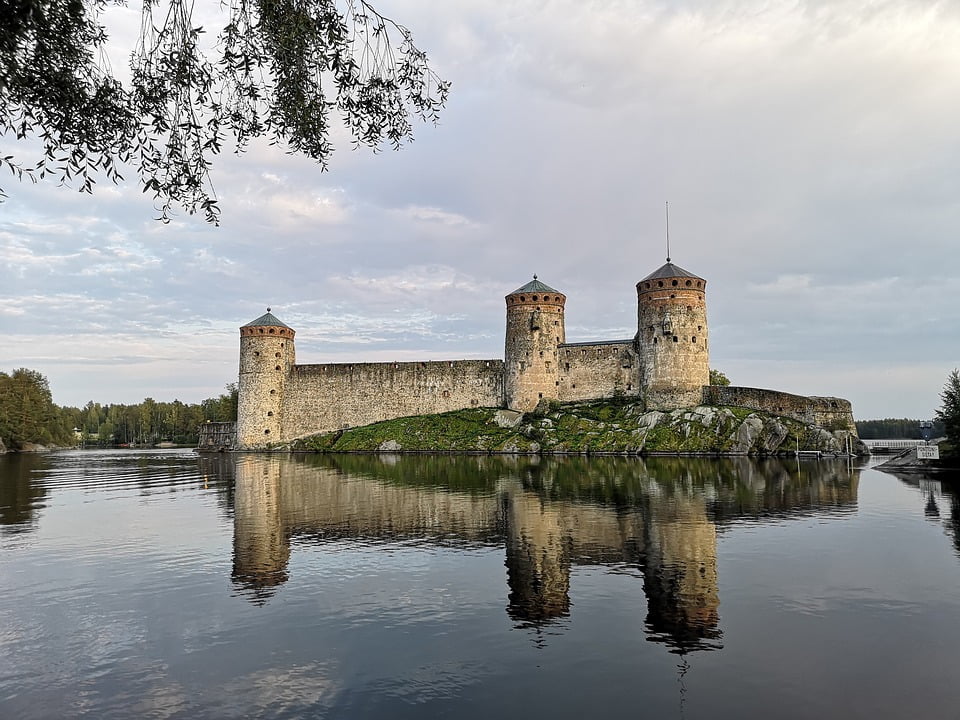 The picturesque view of Olavinlinna Castle and its refelaction on the water.