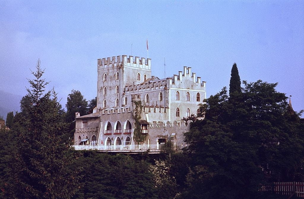 The Itter Castle view from afar surrounded by green trees. 